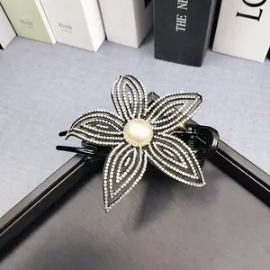 Dettaglio dell'elegante molletta a fiore con strass bianchi e perla al centro