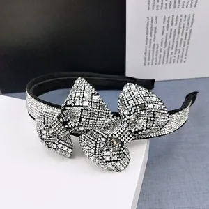 Detail of luxury rhinestone bow headband with shimmering silver crystals on a black base