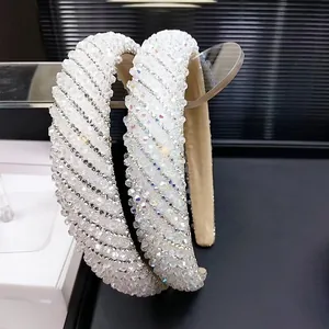 Detailed view of handmade white crystal headband with dense rhinestone patterns