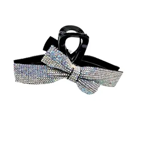 Détail d'une pince à cheveux noire ornée d'un grand nœud serti de strass multicolores