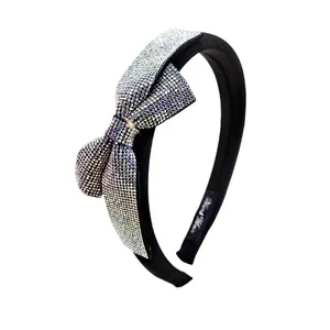 Elegant black sponge headband featuring a large bow embellished with sparkling rainbow rhinestones