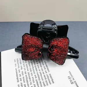 Gros plan d'une élégante pince à cheveux noire avec un grand nœud en strass rouges