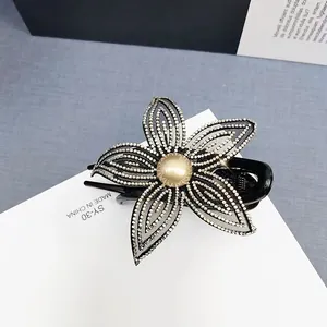 Dettaglio del fermaglio per capelli a fiore con strass d'argento e perla finta centrale