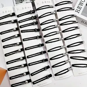 Set de barrettes noires avec perles et strass sur cartes de présentation blanches