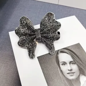 Detailed macro view of an elegant black bow hair clip with shimmering rhinestones