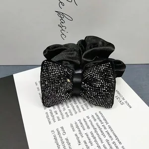 Détail macro d'une pince à cheveux élégante en ruban noir avec strass argentés brillants
