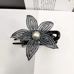 Dettaglio della molletta per capelli a fiore in rete con strass e perla grigia