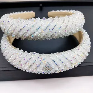 Detail of two white crystal headbands with spiral beads on black display tray