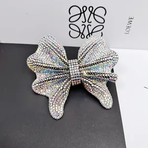 Detailed close-up of a sparkling bow hair clip with multi-colored AB crystal rhinestones