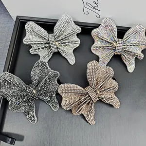 Detailed view of four crystal-encrusted butterfly hair clips in various elegant colors