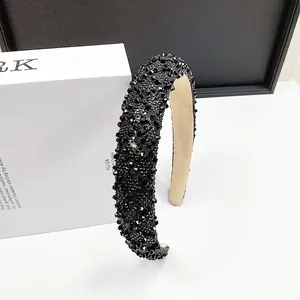 Close-up of sparkling black rhinestone crystal headband with soft beige inner lining