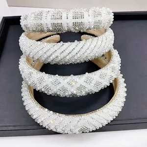 Detailed view of four white crystal beaded headbands with various elegant woven textures