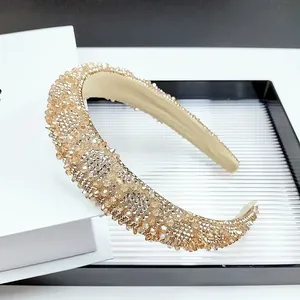 Détail du serre-tête baroque doré champagne orné de cristaux et de strass brillants