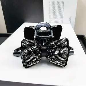 Pince à cheveux nœud noir élégante avec strass argentés et détails en satin chic
