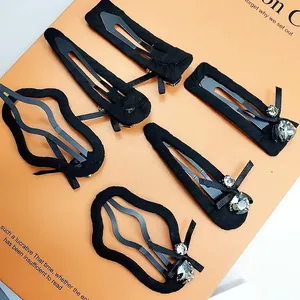 Vue détaillée d'un lot de 6 barrettes noires en tissu avec strass et nœuds en soie