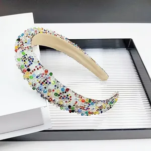 Gros plan détaillé de strass colorés et de perles sur un serre-tête large rembourré