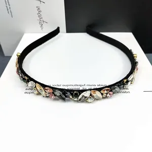 Nahaufnahme des eleganten Haarreifs mit bunten Strasssteinen in Champagner und Grün