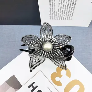Dettaglio dell'elegante molletta a fiore con petali in rete grigia e perla centrale