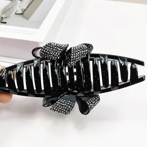 Pince à cheveux noeud avec strass argentés sur un fond blanc au style minimaliste