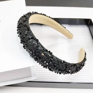 Détail d'un serre-tête baroque serti de cristaux noirs avec doublure intérieure beige