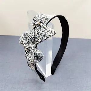 Detailed view of luxury crystal bow headband with sparkling rhinestones on velvet base