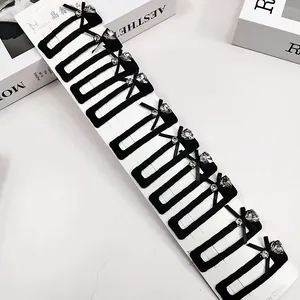 Vue détaillée du lot de 10 barrettes en velours noir avec nœuds et strass brillants
