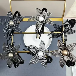 Dettaglio di eleganti mollette per capelli a fiore con strass lucidi e perle fini