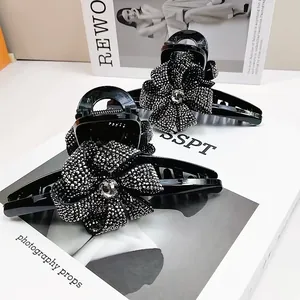 Vue détaillée de la grande pince à cheveux de 13 cm avec roses ornées de strass noirs