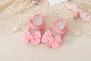 Detail of pink baby princess shoe with 3D rose mesh and rhinestone bow decoration