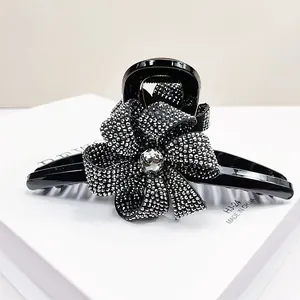 Détail de la pince à cheveux fleur de 13cm avec strass argentés sur finition noire