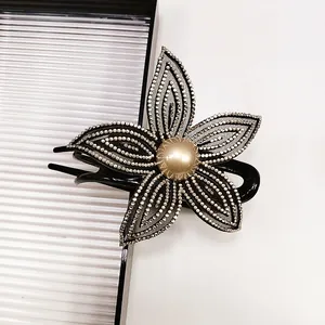 Elegante molletta per capelli a fiore con strass e perla su fondo bianco dal design minimale