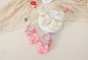 Detailed view of baby girl princess shoes with lace bows in cream and pink colors