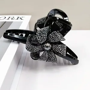 Détail d'une pince à cheveux noire ornée d'une fleur en cristaux brillants élégante