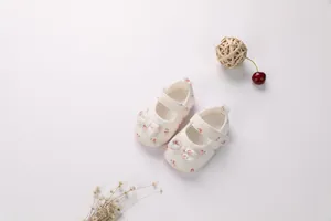Vista dettagliata di scarpe da camminata bianche per neonati con motivi a ciliegia