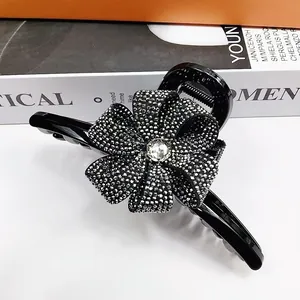 Vue détaillée d'une pince à cheveux noire de 13cm avec un nœud en strass étincelants
