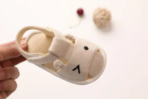 Detail of beige cotton baby sandals with velcro closure and anti-slip soft soles
