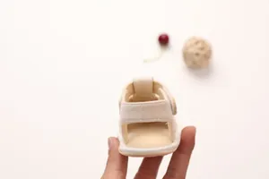 Detail of beige baby walking sandals featuring breathable mesh and velcro heel strap
