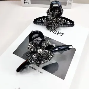 Détail d'une pince à cheveux noire avec une fleur en strass brillants au style élégant