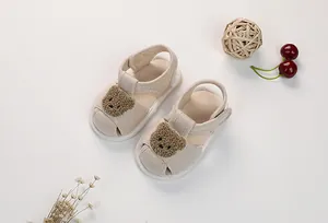 Detail of infant linen sandals featuring 3D plush bear head and non-slip soft sole