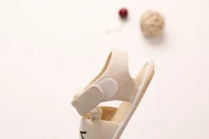 Detail view of cotton baby sandal featuring adjustable velcro strap and soft texture