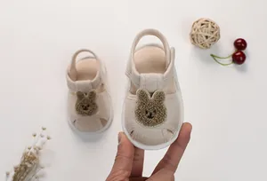 Detail of infant soft-sole sandals with cute plush bear patch and protective toe cap