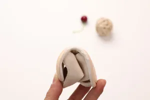 Flexible soft-sole baby sandal in beige cotton showing high flexibility and foldability