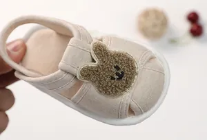 Detail view of baby canvas sandal with plush rabbit embroidery and velcro strap