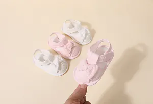 Vue détaillée de sandales d'été pour bébé avec broderie dentelle et nœud papillon