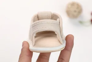 Detail of adjustable hook-and-loop heel strap on beige cotton baby walking sandals