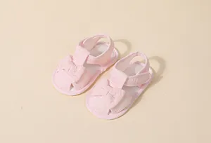 Détail de sandales roses pour bébé avec nœud en dentelle et semelle souple antidérapante