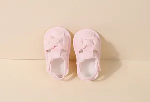 Vue détaillée de sandales roses pour bébé avec broderie en dentelle et noeud décoratif