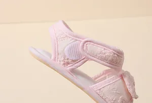 Détail de sandales roses pour bébé avec broderie florale et fermeture par velcro