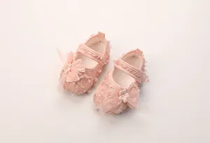 Detaillierte Draufsicht auf rosa Baby-Mary-Janes mit Spitze und floraler Schleifenverzierung