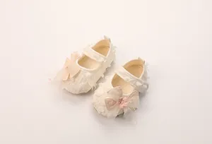 Detailansicht der Baby-Mary-Jane-Schuhe mit Spitzenstruktur und rosa Schleife
